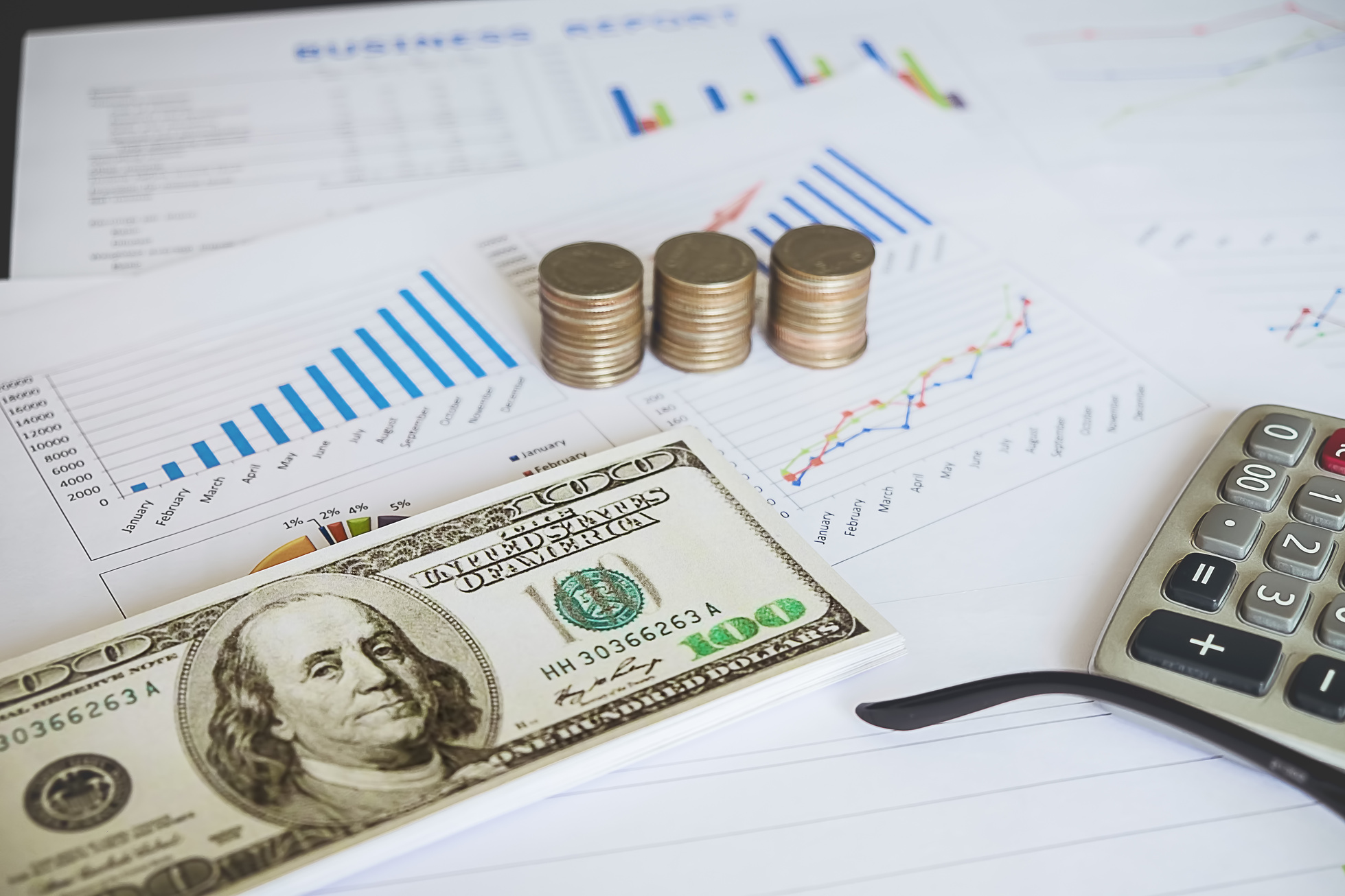 Money and Calculator on Business Financial Report.